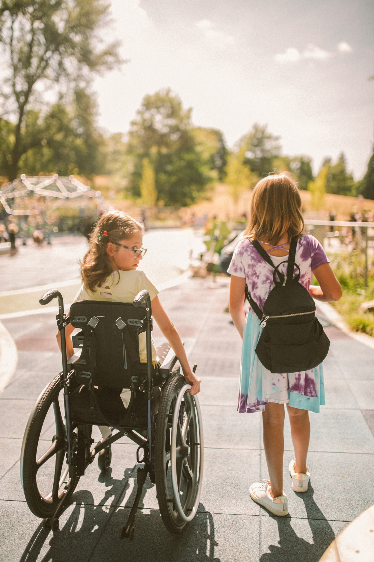 Parks and Rec Child in Wheelchair and Girl Outdoors